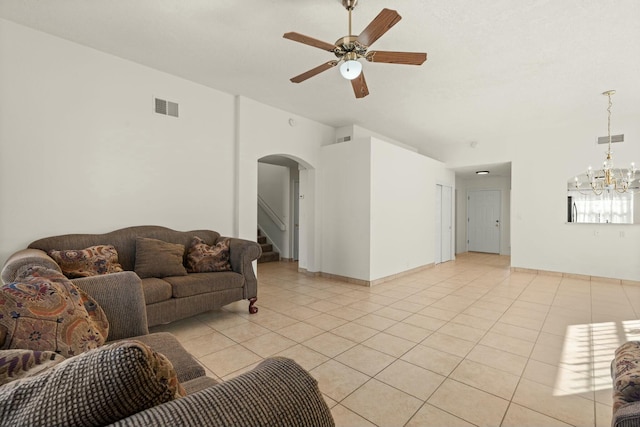 living room with light tile patterned flooring and ceiling fan with notable chandelier