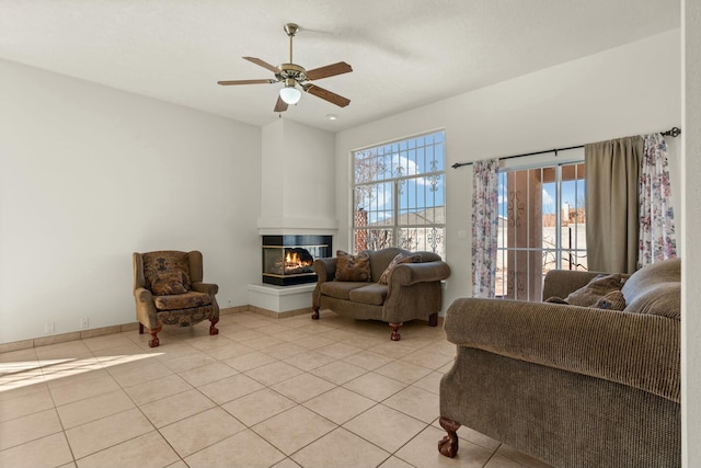 tiled living room with ceiling fan and a multi sided fireplace