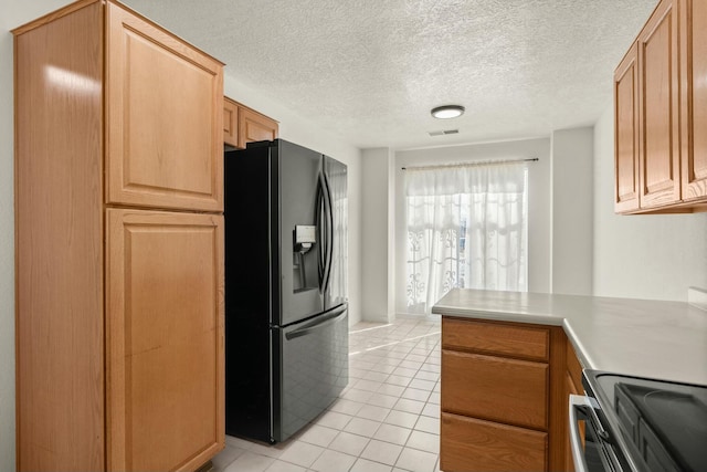 kitchen featuring black refrigerator with ice dispenser, light tile patterned floors, light brown cabinets, a textured ceiling, and electric stove