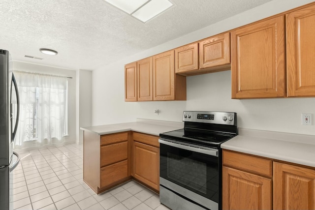 kitchen featuring light tile patterned floors, a textured ceiling, and appliances with stainless steel finishes