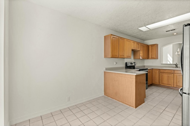 kitchen with sink, a textured ceiling, light tile patterned floors, kitchen peninsula, and stainless steel appliances