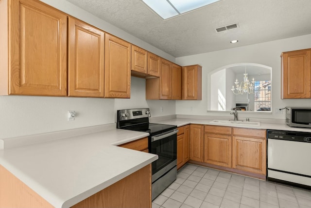 kitchen featuring sink, a chandelier, hanging light fixtures, kitchen peninsula, and stainless steel appliances