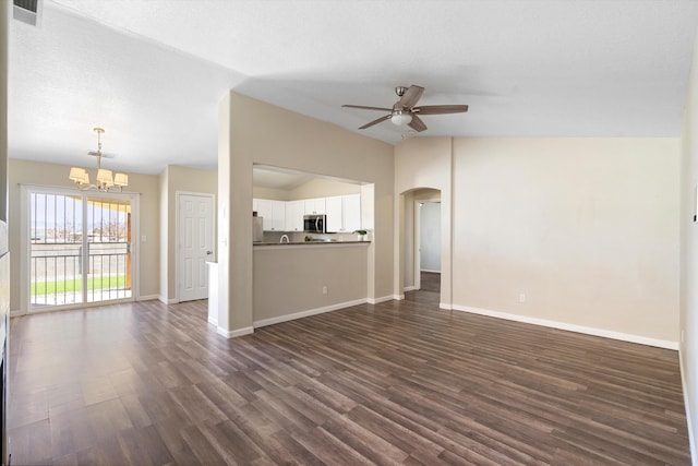 unfurnished living room with dark hardwood / wood-style flooring, ceiling fan with notable chandelier, vaulted ceiling, and a textured ceiling