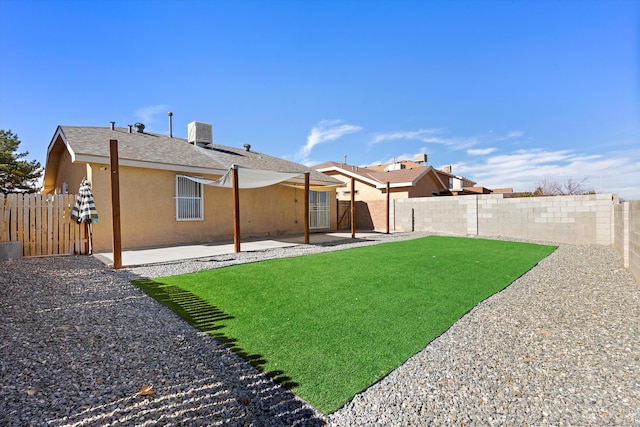 rear view of property featuring a lawn, central AC, and a patio area