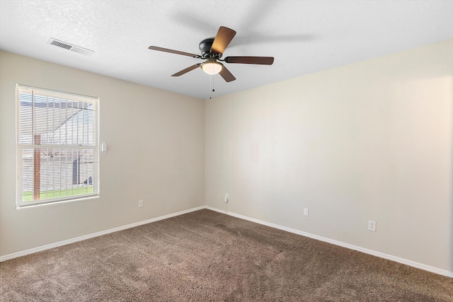 empty room with ceiling fan, carpet, and a textured ceiling