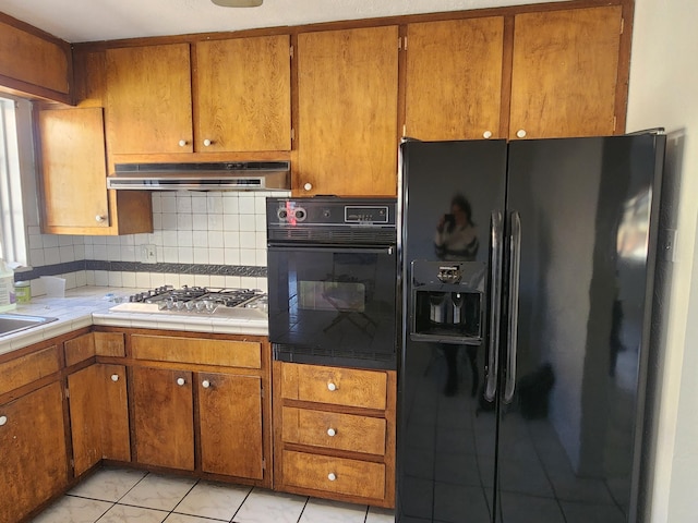 kitchen with backsplash, tile countertops, black appliances, and sink