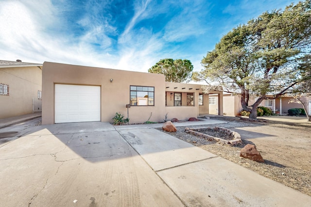 pueblo revival-style home with a garage