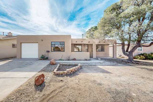 pueblo-style home with a garage