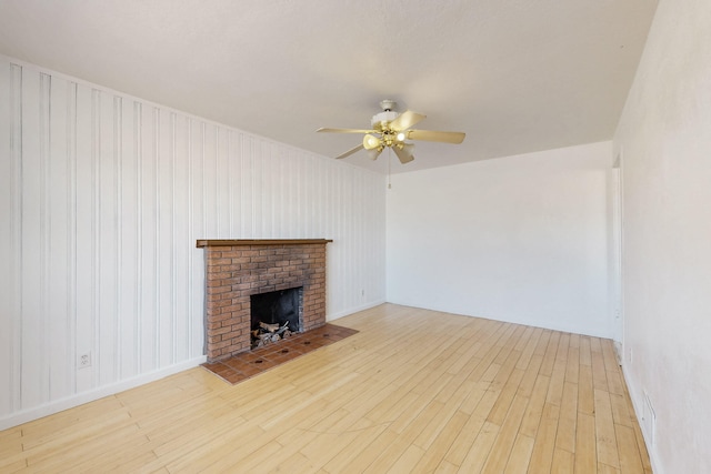 unfurnished living room featuring ceiling fan, a fireplace, and light hardwood / wood-style floors