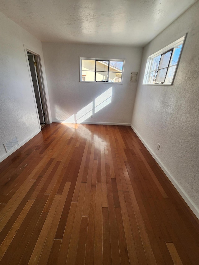 empty room with hardwood / wood-style flooring and a textured ceiling