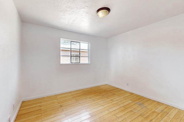 empty room featuring light hardwood / wood-style floors and a textured ceiling