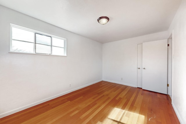 unfurnished room with wood-type flooring