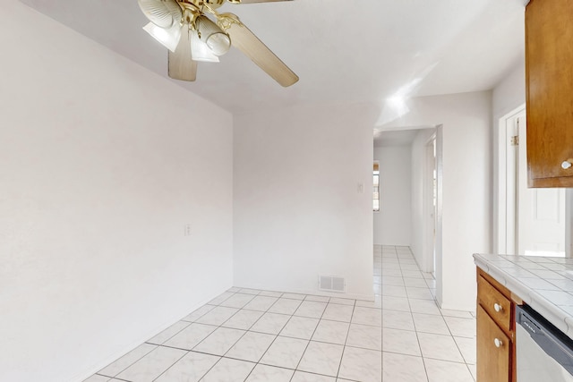 spare room with ceiling fan and light tile patterned floors