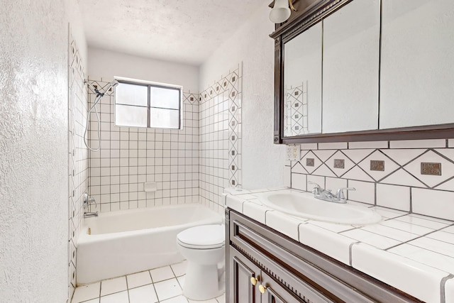 full bathroom with tiled shower / bath, tasteful backsplash, vanity, toilet, and a textured ceiling