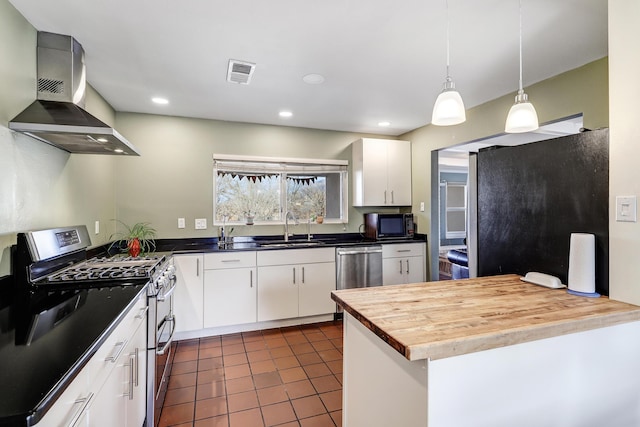 kitchen featuring stainless steel appliances, white cabinetry, sink, and pendant lighting