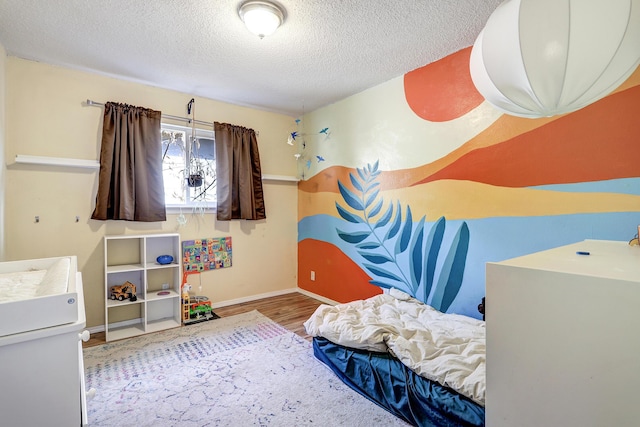 bedroom with hardwood / wood-style flooring and a textured ceiling