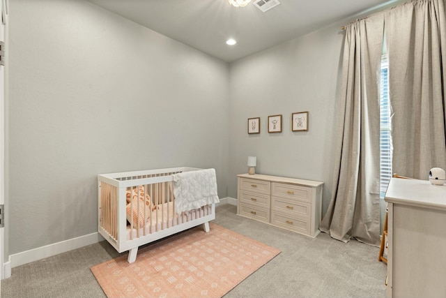 bedroom with a nursery area and light colored carpet