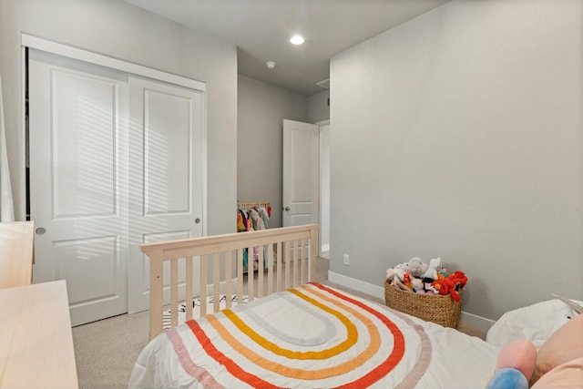 bedroom featuring light carpet and a closet