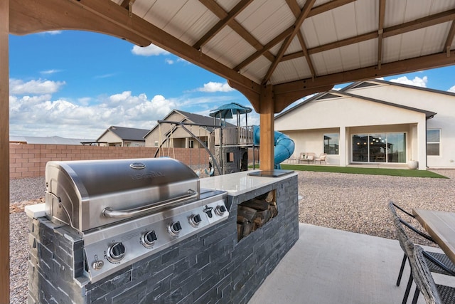 view of patio / terrace featuring a gazebo, grilling area, and exterior kitchen