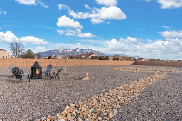 view of yard with a mountain view and an outdoor fire pit