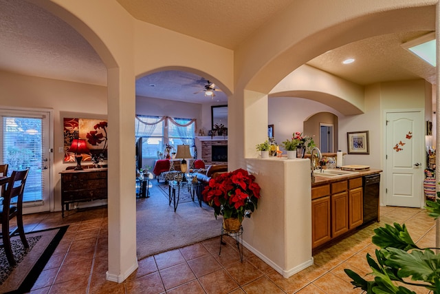 kitchen featuring ceiling fan, sink, a textured ceiling, and light tile patterned floors