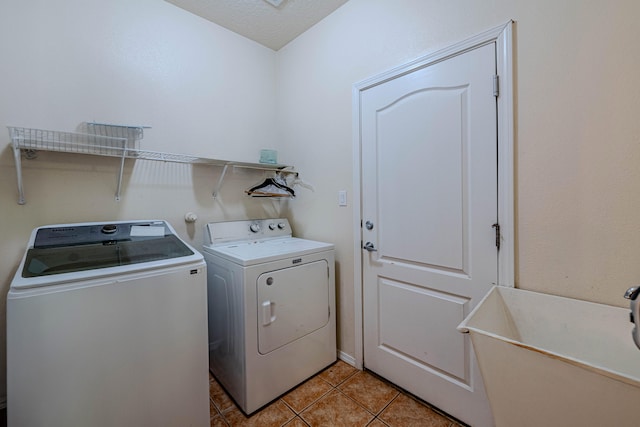 laundry area featuring independent washer and dryer, sink, and light tile patterned floors