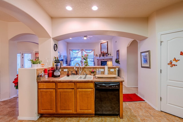 kitchen featuring sink, a textured ceiling, plenty of natural light, dishwasher, and ceiling fan