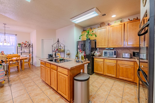 kitchen with tasteful backsplash, a center island, light tile patterned floors, pendant lighting, and black appliances