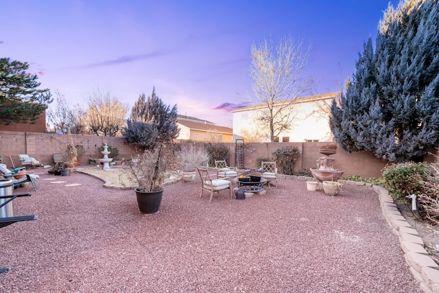 patio terrace at dusk featuring an outdoor fire pit