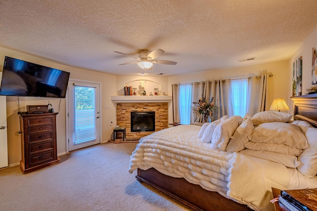 bedroom featuring a fireplace, access to exterior, ceiling fan, light carpet, and a textured ceiling