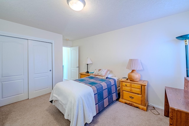 carpeted bedroom featuring a closet and a textured ceiling