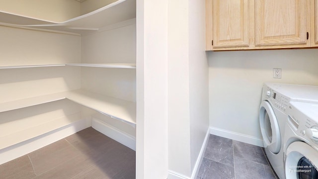 clothes washing area featuring cabinets and independent washer and dryer