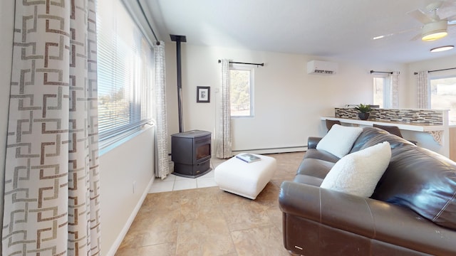 living room with a baseboard heating unit, a wood stove, and a wall unit AC