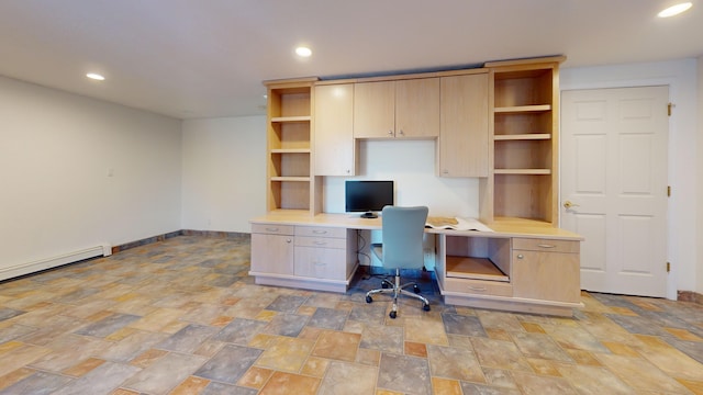 unfurnished office with built in desk and a baseboard radiator