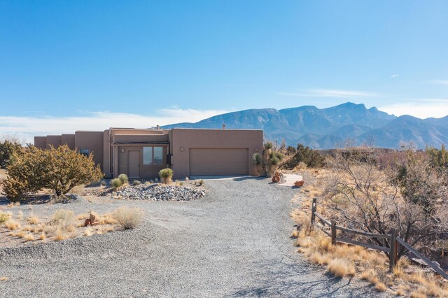 pueblo-style home with a mountain view and a garage