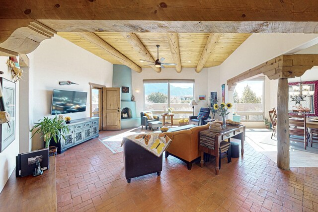 living room with beam ceiling, ceiling fan with notable chandelier, and wooden ceiling