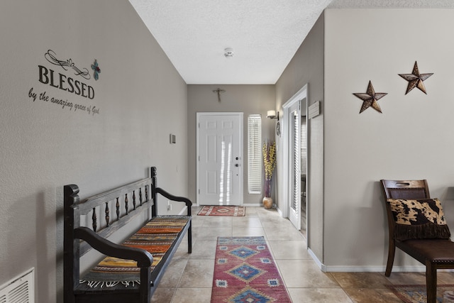 entrance foyer featuring light tile patterned floors and a textured ceiling