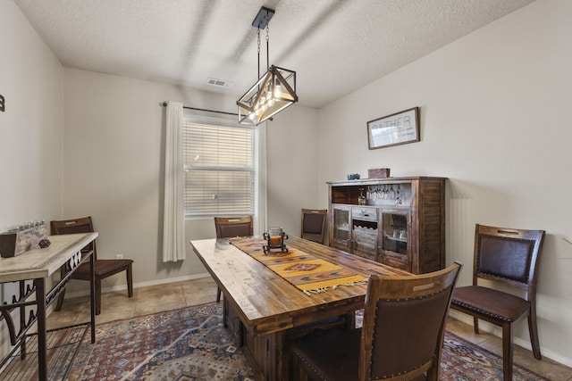 tiled dining room with a textured ceiling