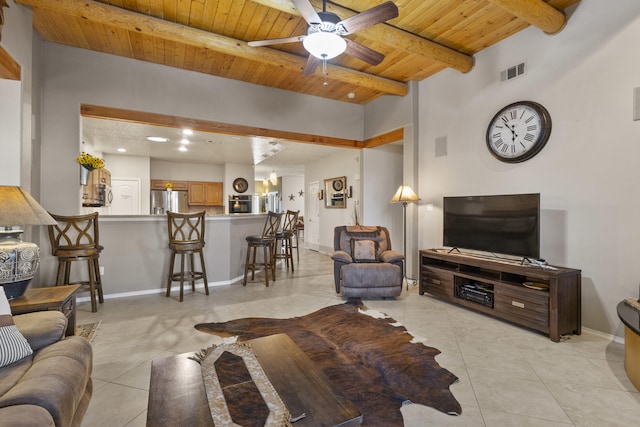 tiled living room featuring beamed ceiling, ceiling fan, and wood ceiling