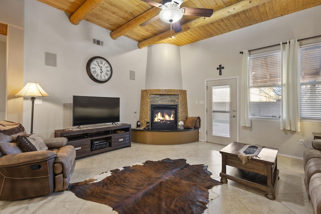 living room with light tile patterned floors, a premium fireplace, ceiling fan, wooden ceiling, and beamed ceiling