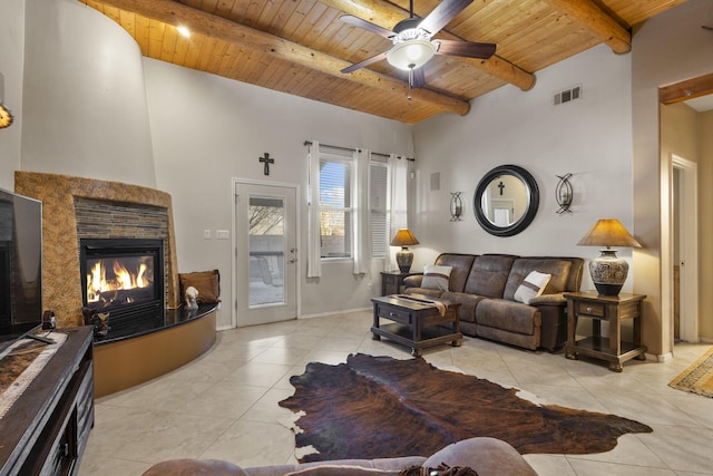 tiled living room featuring ceiling fan, wooden ceiling, and beamed ceiling