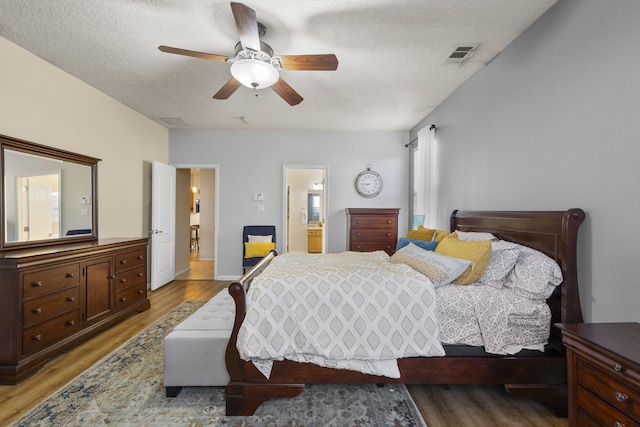 bedroom featuring ceiling fan, light hardwood / wood-style floors, and a textured ceiling