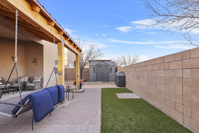 view of yard featuring outdoor lounge area, a patio, and a storage unit