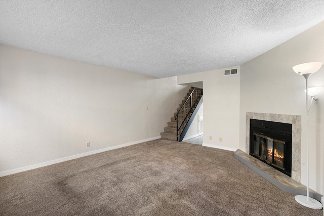 unfurnished living room featuring a textured ceiling and carpet