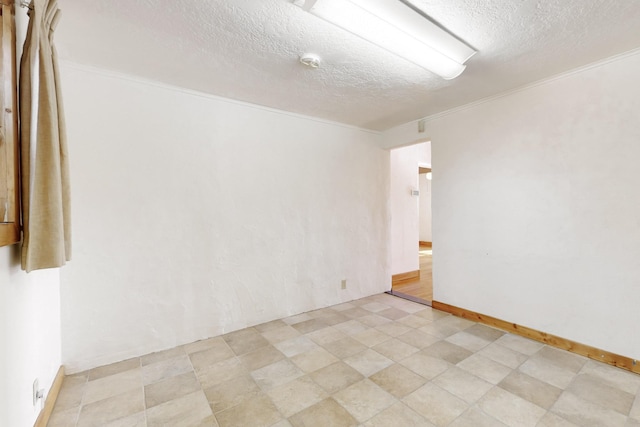 unfurnished room with ornamental molding and a textured ceiling