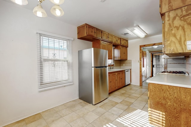 kitchen featuring tasteful backsplash, sink, pendant lighting, and stainless steel appliances