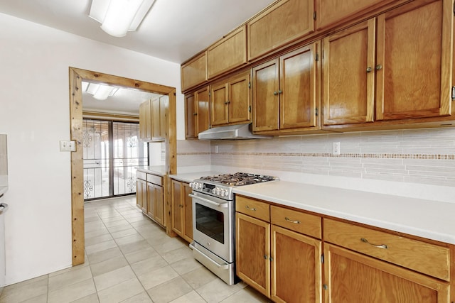 kitchen with tasteful backsplash, light tile patterned floors, and gas stove