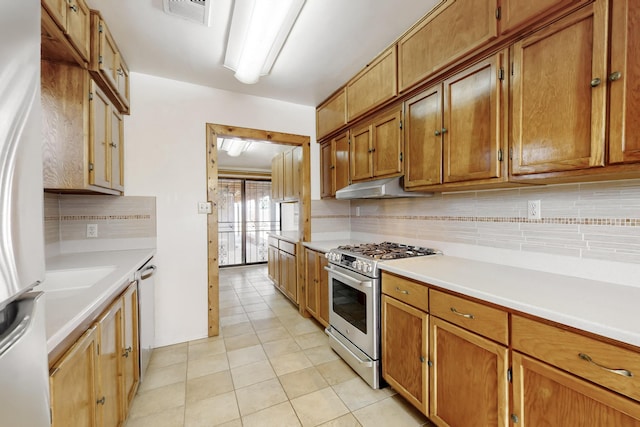 kitchen with stainless steel appliances, decorative backsplash, and light tile patterned floors