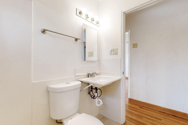 bathroom with wood-type flooring and toilet