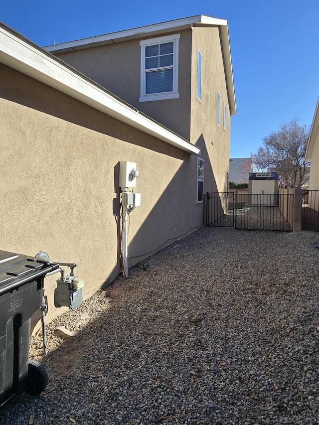 view of property exterior featuring fence and stucco siding